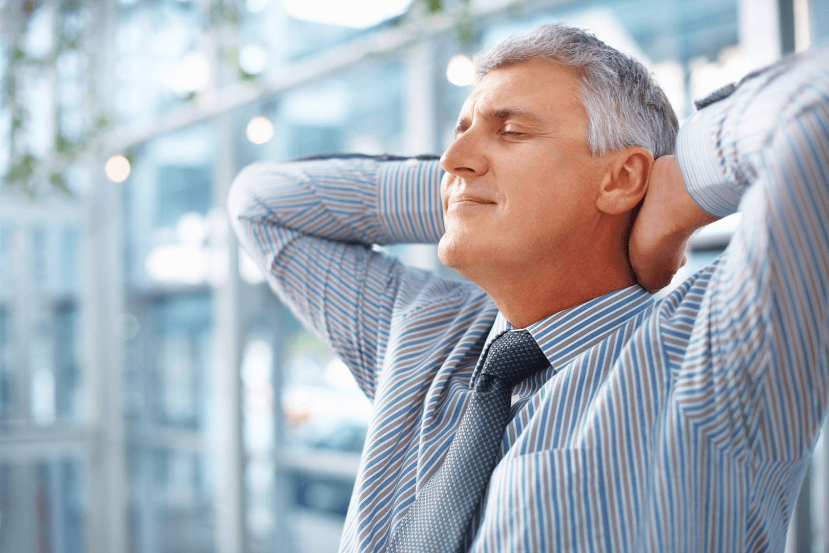 Zrelaksowany przedsiębiorca z uśmiechem i rękami za głową