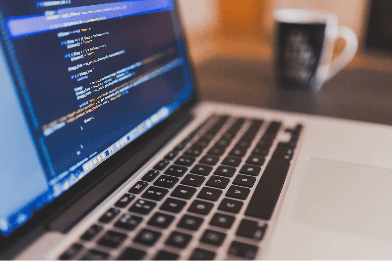 Zbliżenie na ekran laptopa z widocznymi liniami kolorowego kodu programistycznego – symbol nowoczesnych narzędzi i fundamentów technicznych.
